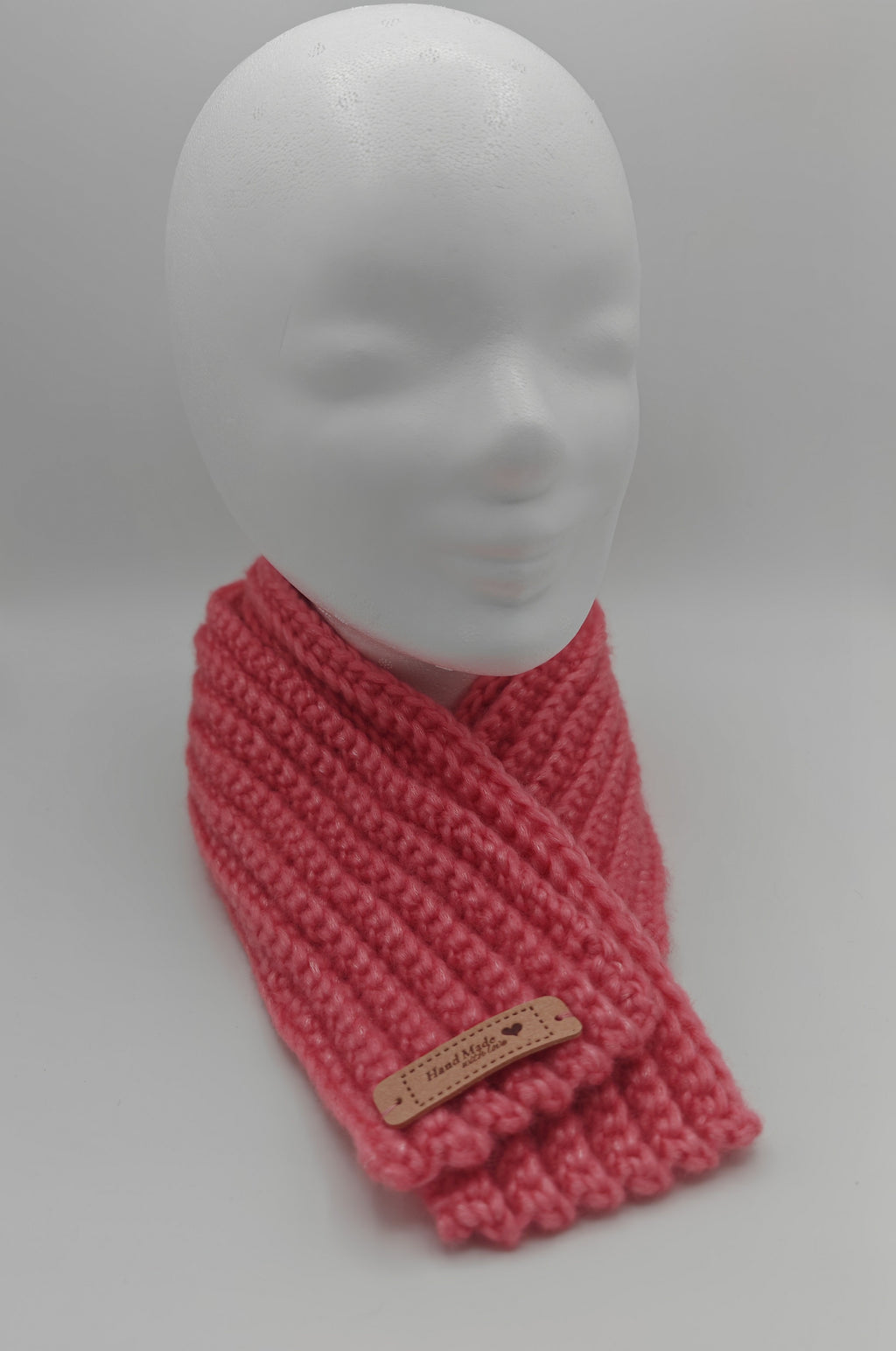 Rosa gehäkelter Schal als Halswärmer auf Puppenkopf