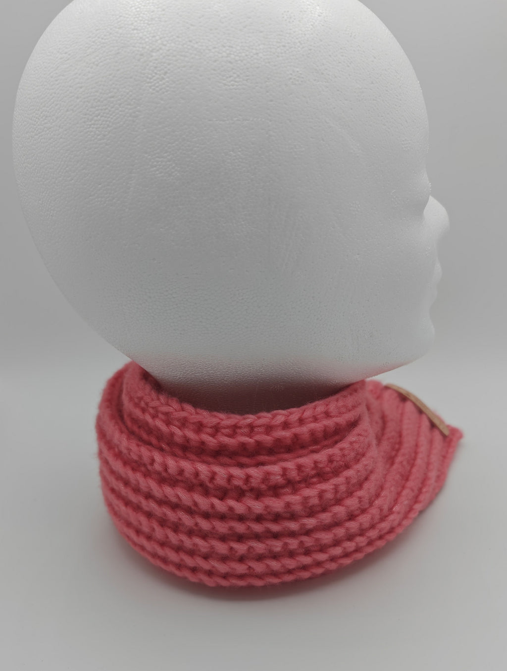 Rosa Winterschal in Häkeloptik eng um den Hals getragen