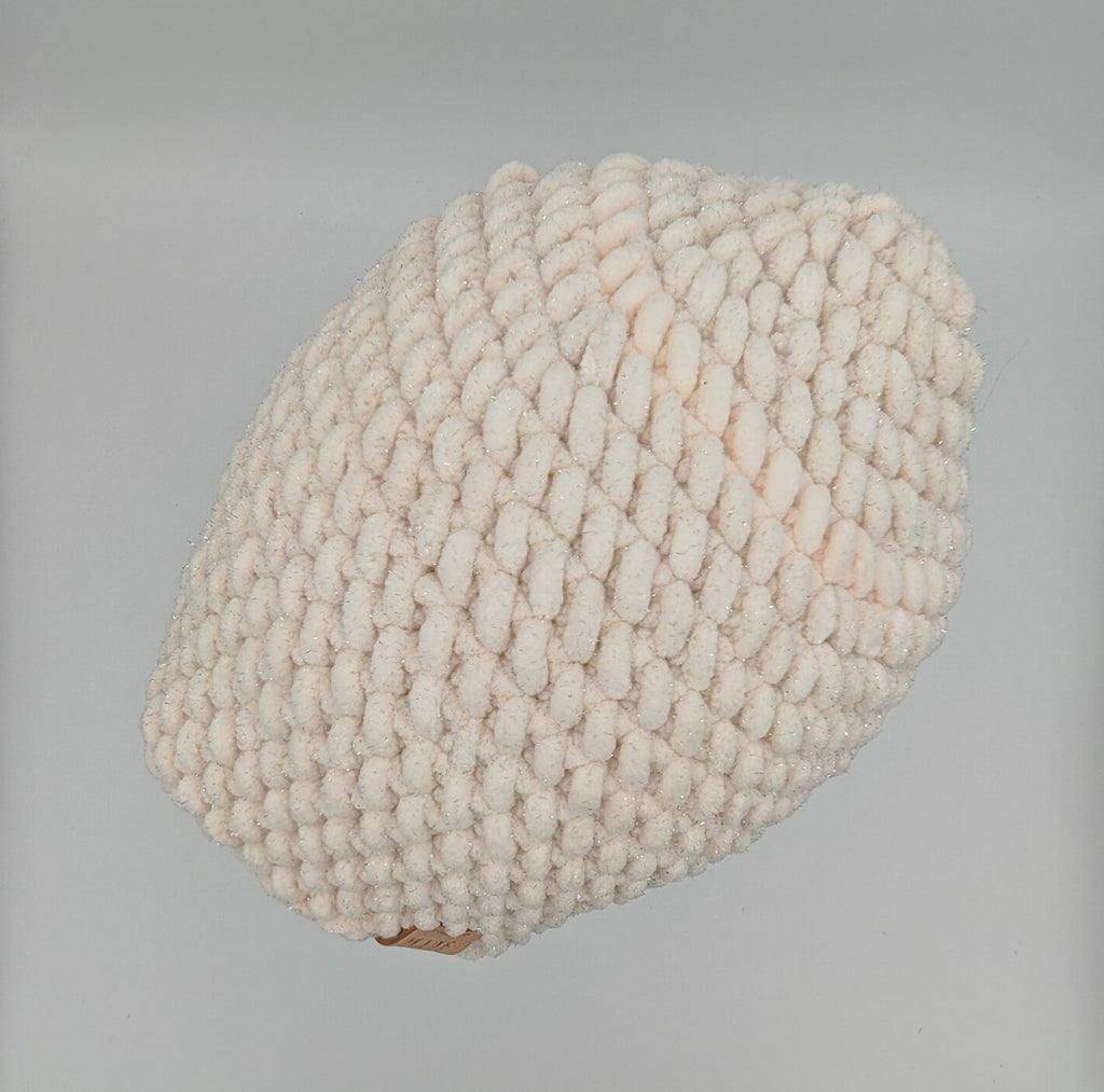 Handgehäkelte Beanie in Creme mit feinem Glitzerschimmer, flach liegend, Chunky Crochet Struktur