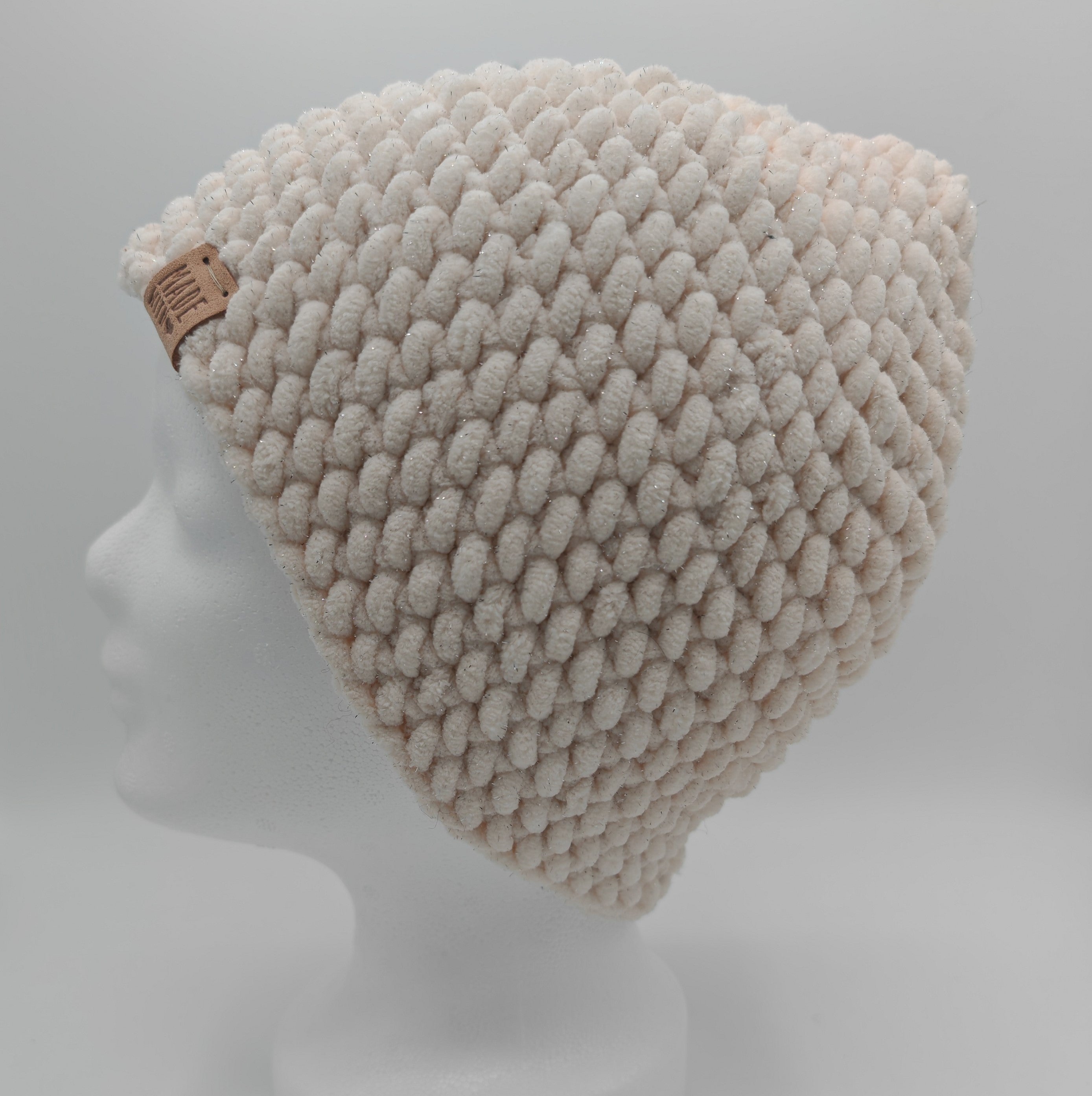 Gehäkelte Beanie mit Glitzergarn in Creme, Seitenansicht mit Handmade Label