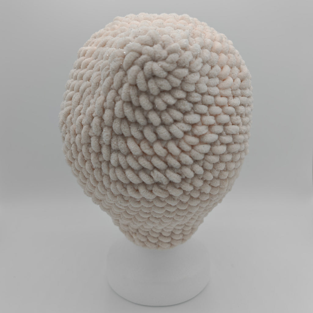 Gehäkelte Chunky Beanie in Creme mit dezentem Glitzer, Rückansicht auf Schaufensterkopf