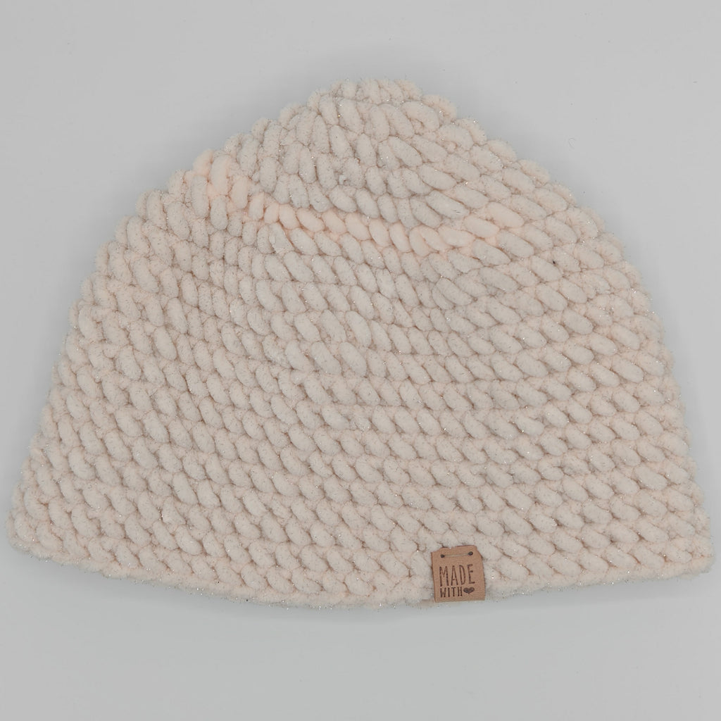 Handgehäkelte Beanie in Creme mit dezentem Glitzer, flach liegend, gleichmäßiges Häkelmuster