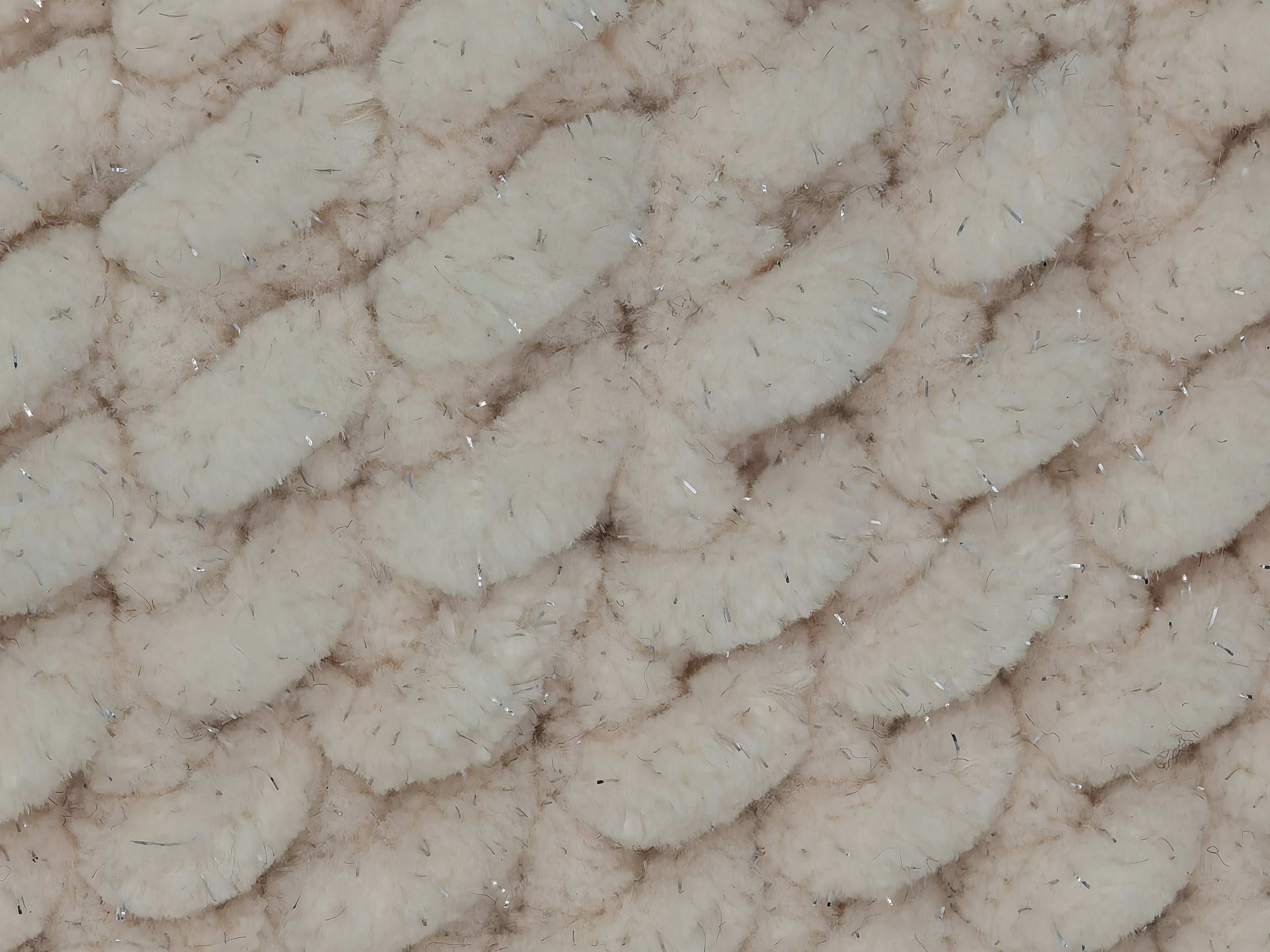 Detailaufnahme einer handgehäkelten Beanie in Creme mit feinem Glitzerschimmer, weiche Chenillegarn-Struktur