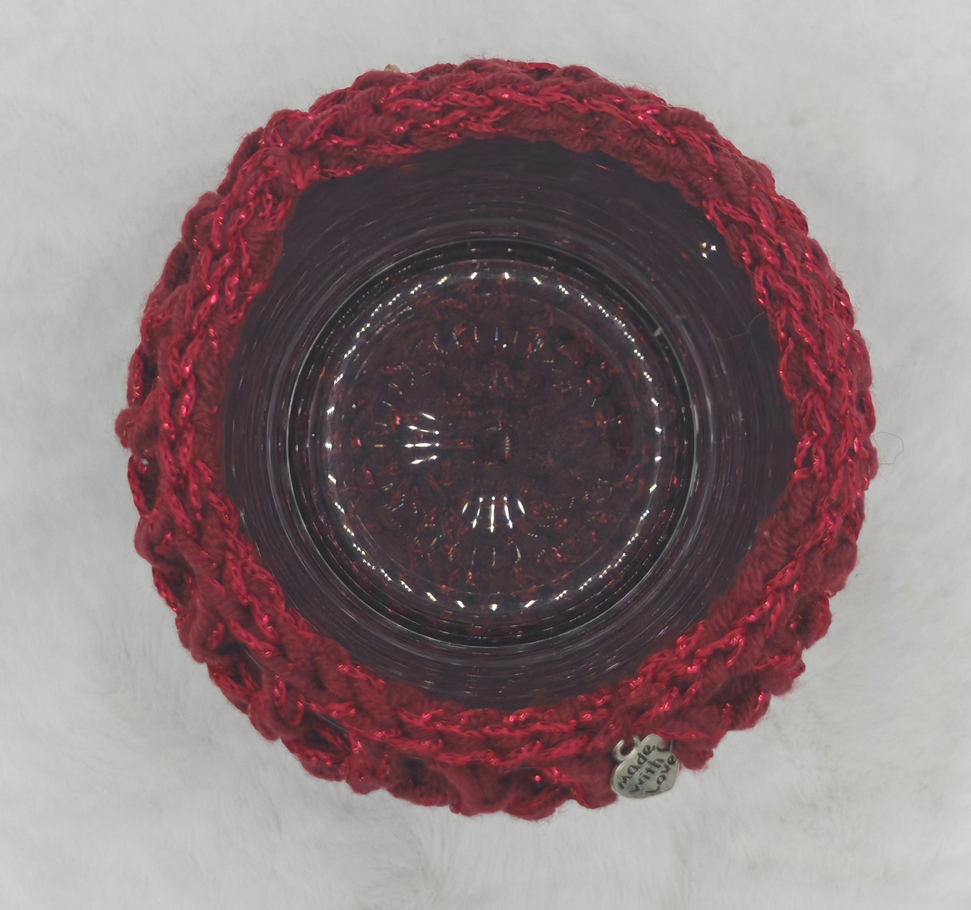 Dekoratives rotes Häkel-Windlicht auf hellem Untergrund